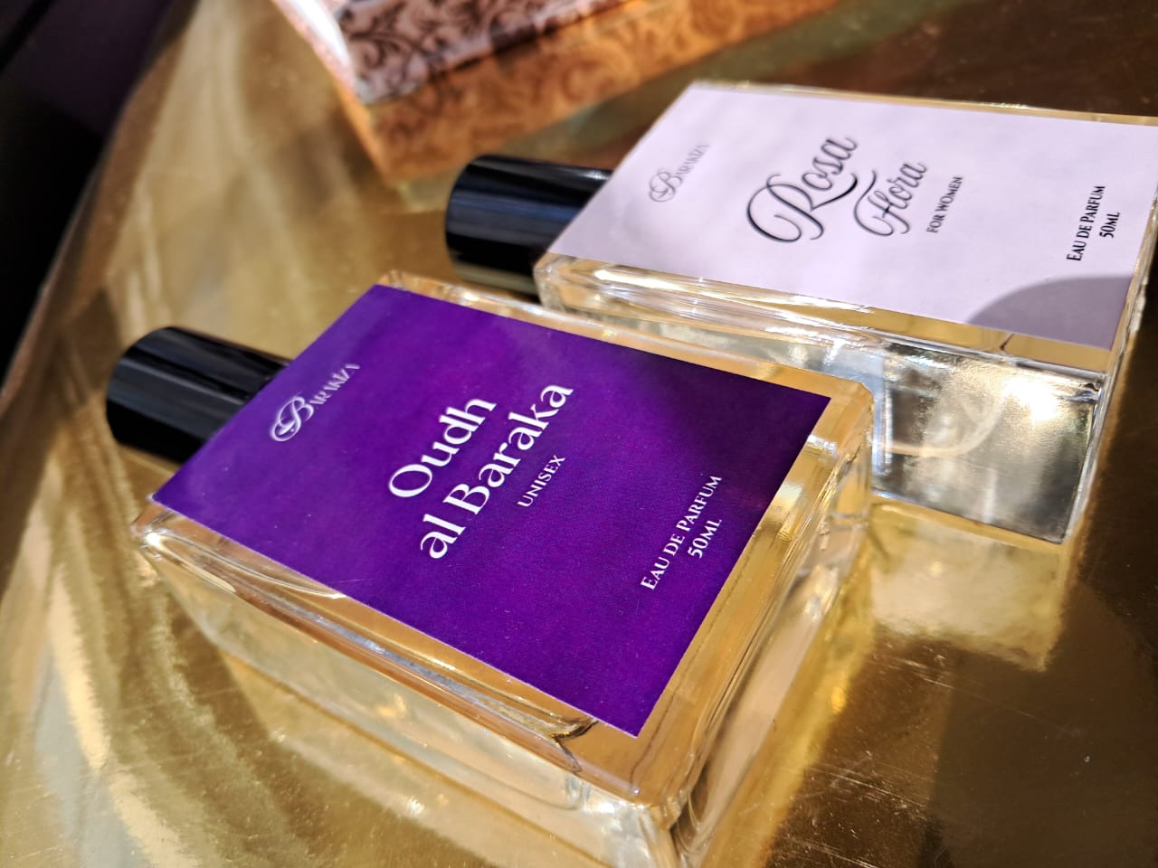 Perfume bottle with purple label on a reflective surface
