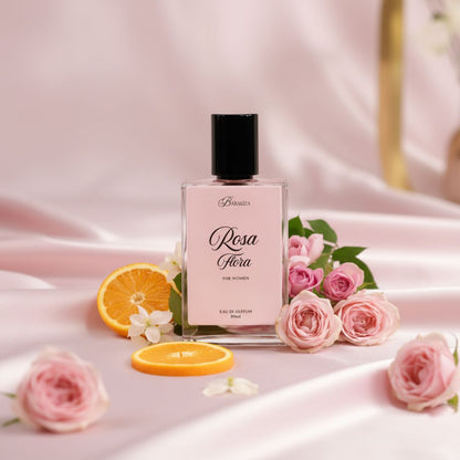 Perfume bottle labeled 'Rosa Flora' with pink roses and oranges on a soft pink background